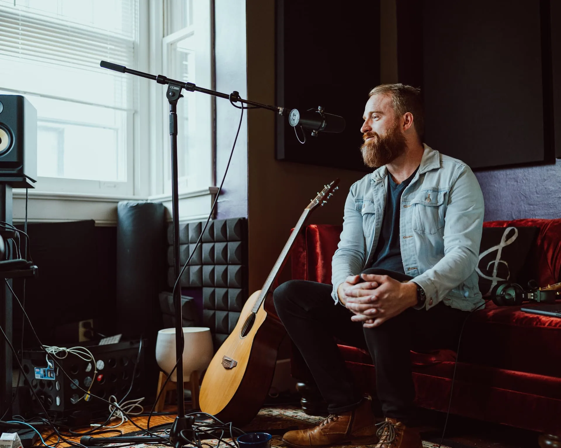 Roger Jæger with an acoustic guitar in the recording studio