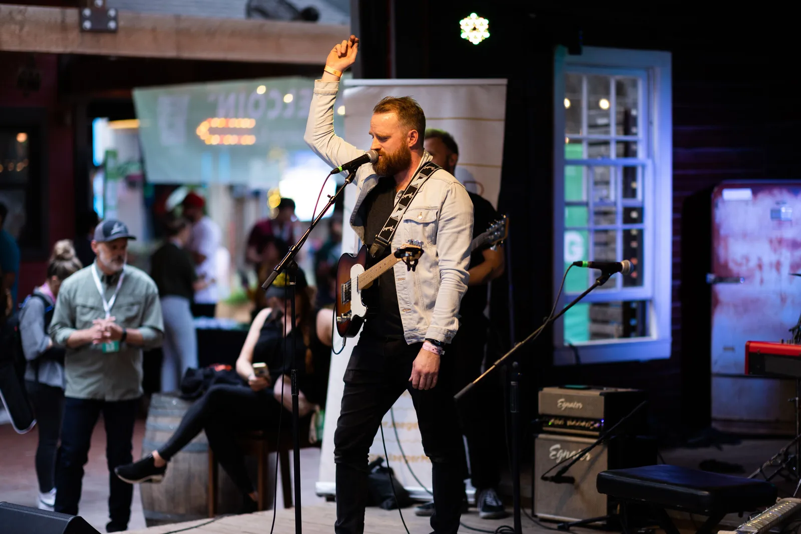 Roger singing at SXSW, arm raised, electric guitar