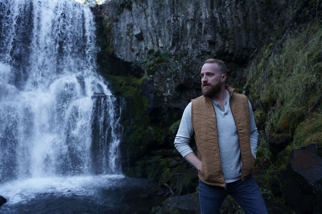 Roger standing by blue water and a waterfall