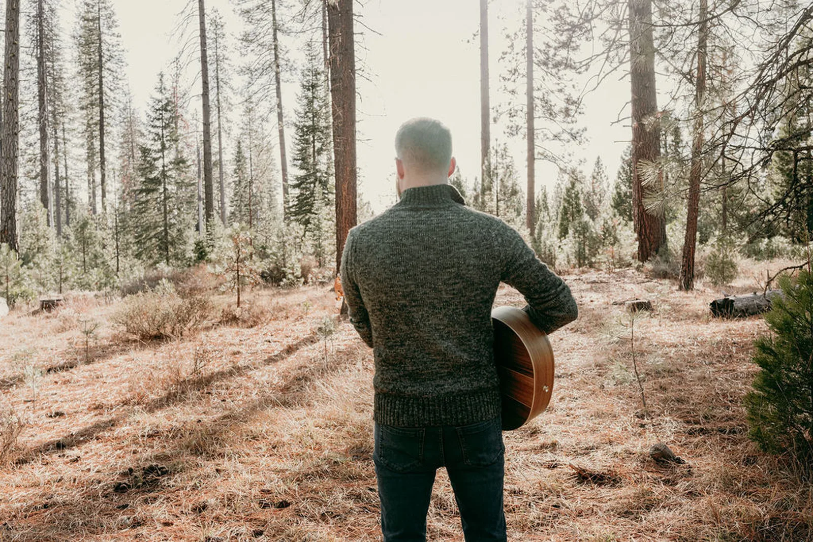 Roger walking into the pines with his guitar